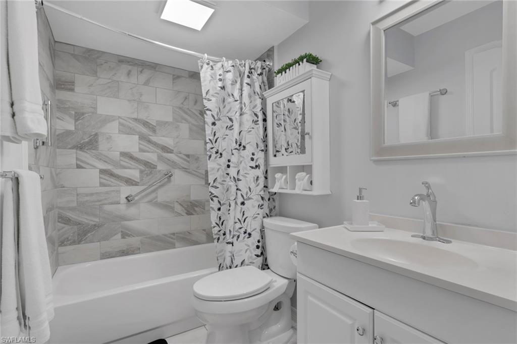 Full bathroom featuring a white vanity with integrated sink, framed mirror, and built-in medicine cabinet