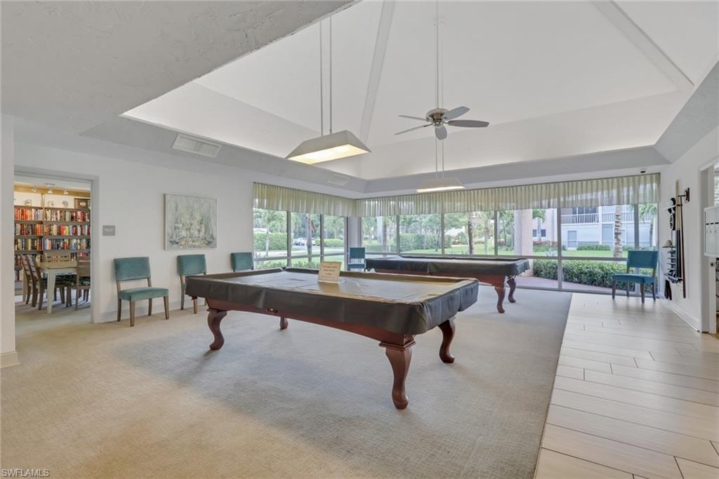 Recreation room featuring two billiards tables, extensive window walls, carpet flooring, a vaulted ceiling, and recessed lighting