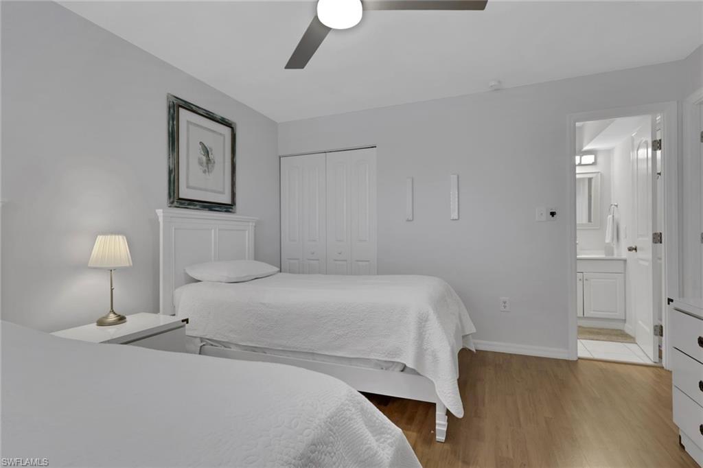 Light-toned wood-finish flooring complements the neutral wall color in this room, featuring a ceiling fan with integrated lighting