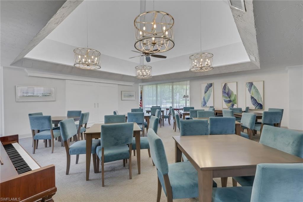 Spacious common area featuring recessed lighting, multiple chandeliers, a ceiling fan, and carpeted flooring