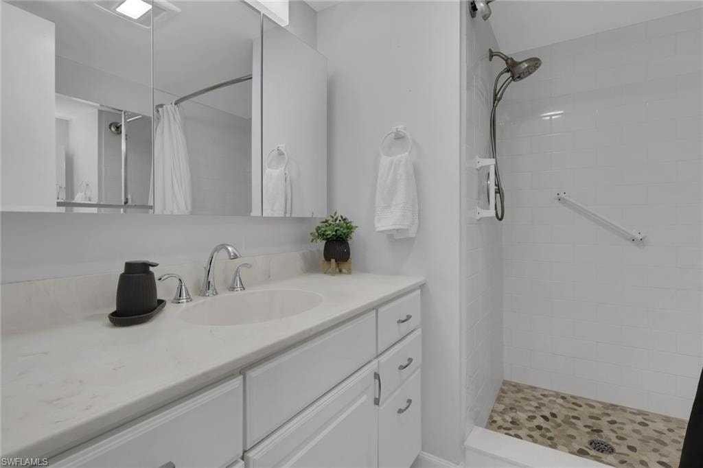Bathroom featuring a white vanity with an undermount sink and chrome fixtures