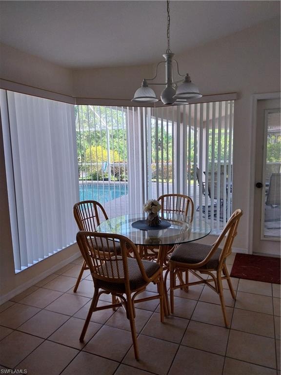 Dining space with light tile patterned floors and a chandelier