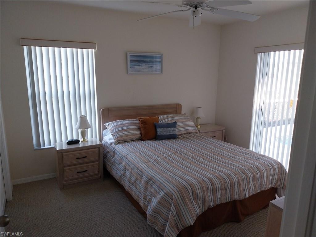 Bedroom featuring multiple windows, light carpet, and ceiling fan