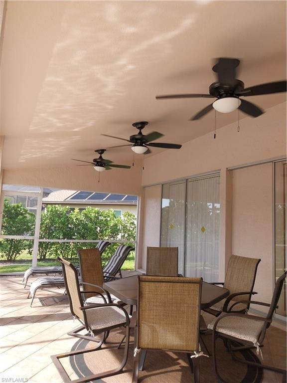 Sunroom / solarium with a ceiling fan and outdoor dining space