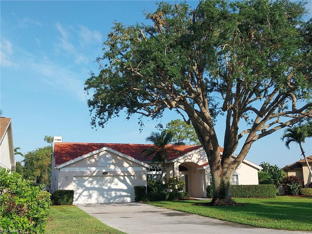 Mediterranean / spanish house with an attached garage, driveway, a front lawn, and stucco siding