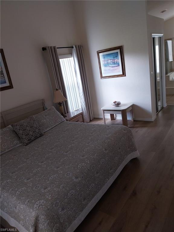 Bedroom with wood finished floors and connected bathroom