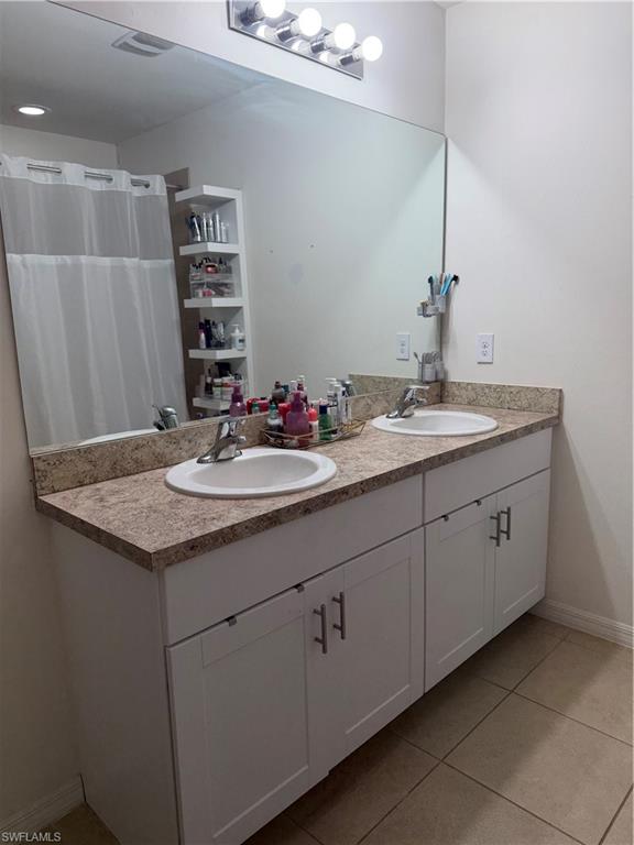 Dual vanity featuring white shaker-style cabinetry, speckled countertops, and undermount sinks