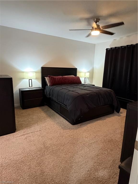 Bedroom featuring neutral carpeting and a ceiling fan with integrated lighting