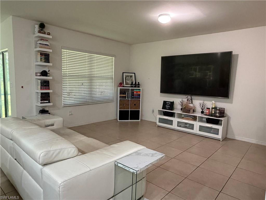 Spacious interior room featuring light-toned tile flooring throughout