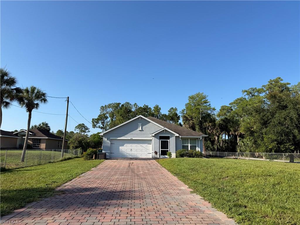 Single-story residence featuring a two-car garage and a brick paver driveway