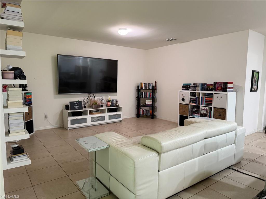 Spacious living area featuring neutral-toned tile flooring throughout