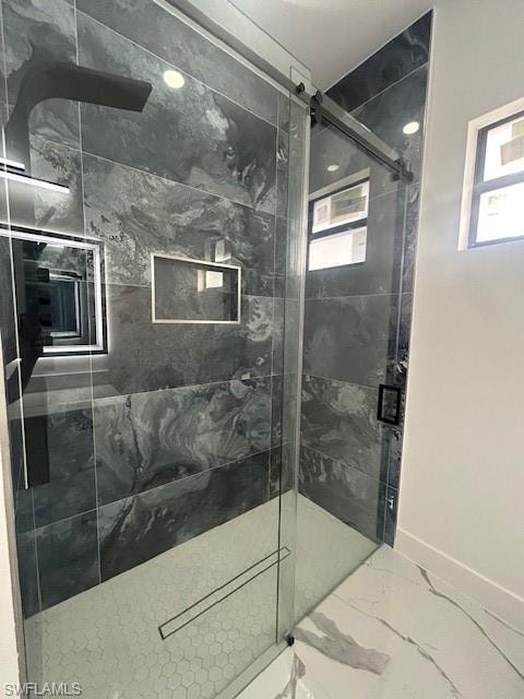 Bathroom featuring a marble finish shower and marble look tiles