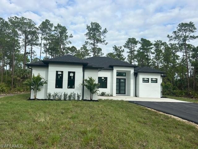 View of front of home featuring a front yard and stucco siding