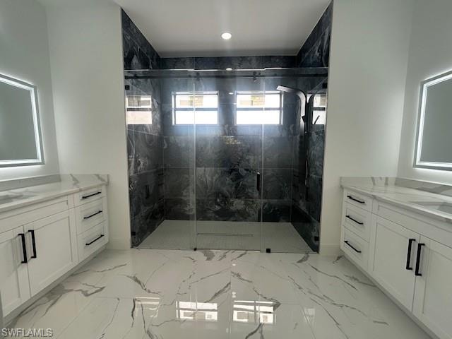 Bathroom with two vanities, a marble finish shower, and light marble finish floors