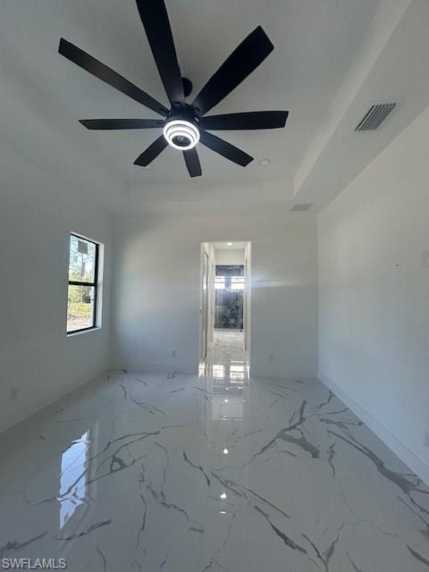 Unfurnished room with light marble finish floors, a tray ceiling, and recessed lighting