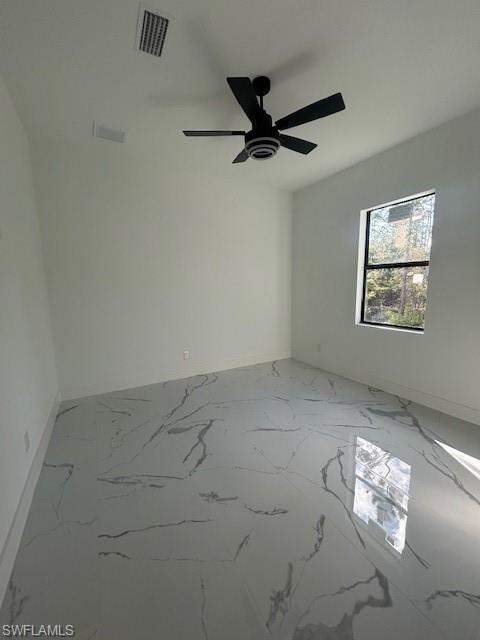 Spare room featuring light marble finish flooring and ceiling fan
