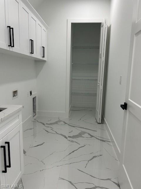 Laundry room featuring cabinet space, hookup for a washing machine, light marble finish flooring, and electric dryer hookup