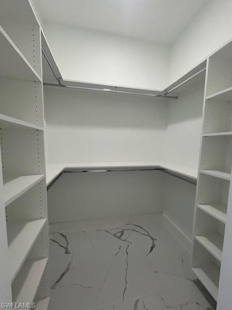 Spacious closet featuring marble look tiles