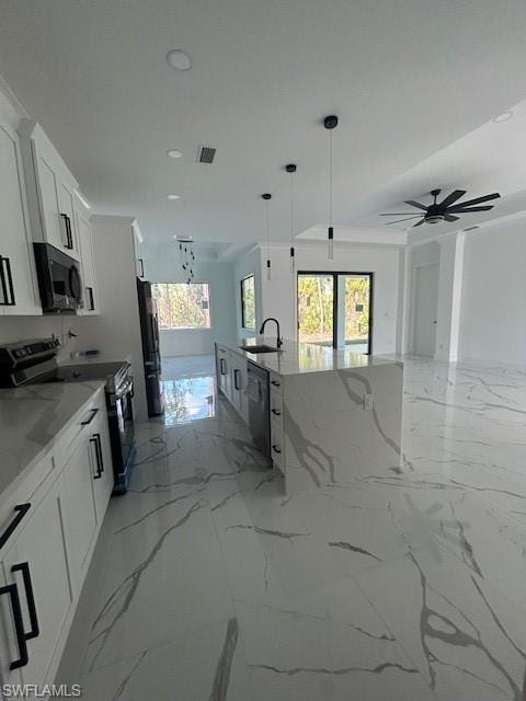 Kitchen with light marble finish flooring, stove, light stone counters, hanging light fixtures, and recessed lighting