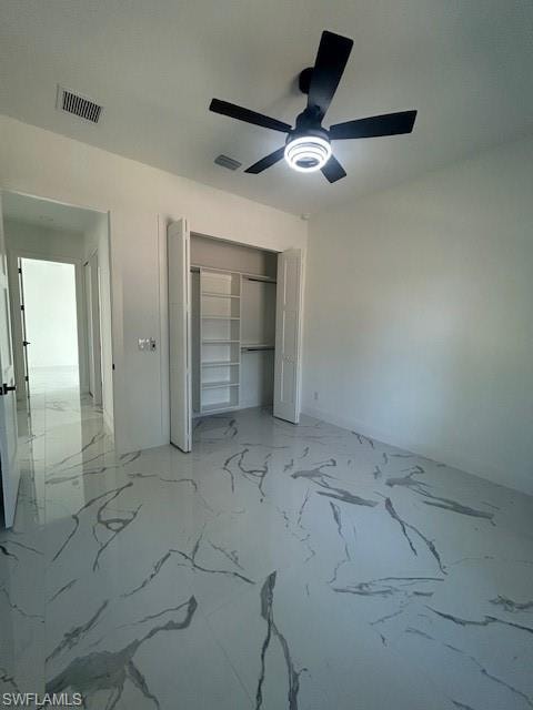 Unfurnished bedroom featuring light marble finish flooring, ceiling fan, and a closet