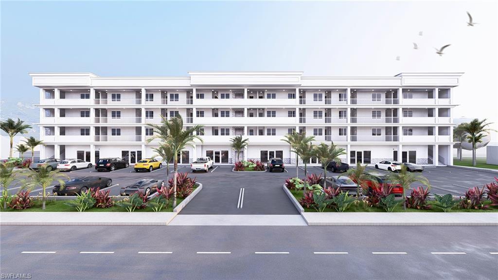 View of apartment building / complex featuring uncovered parking