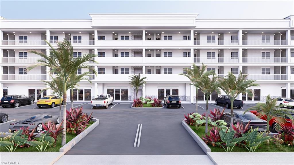 View of apartment building / complex featuring uncovered parking