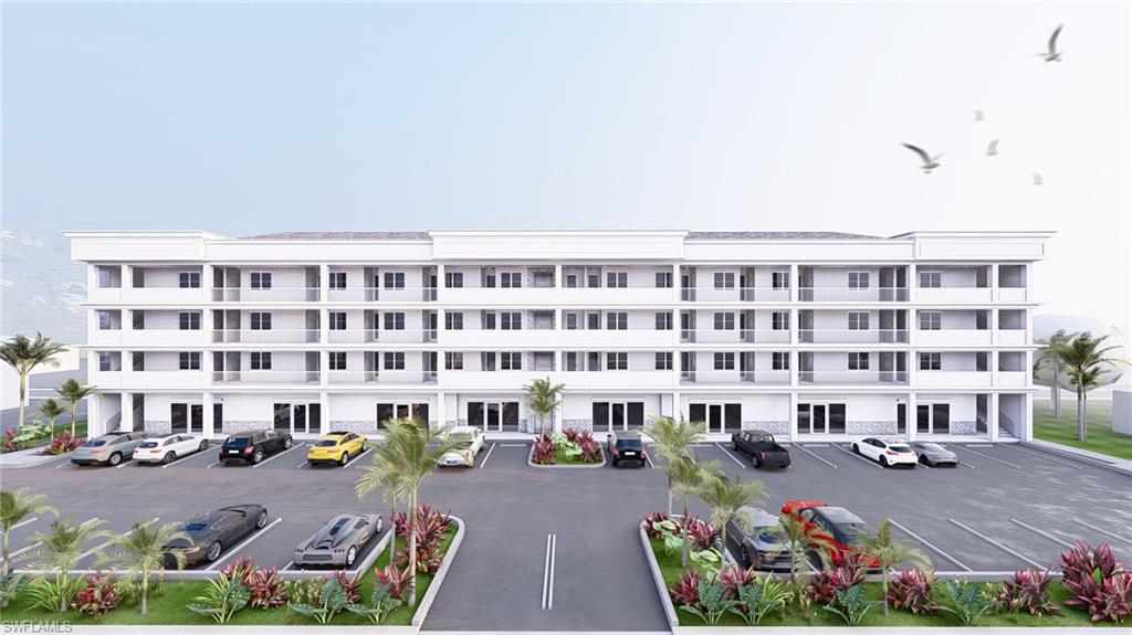 View of apartment building / complex featuring uncovered parking