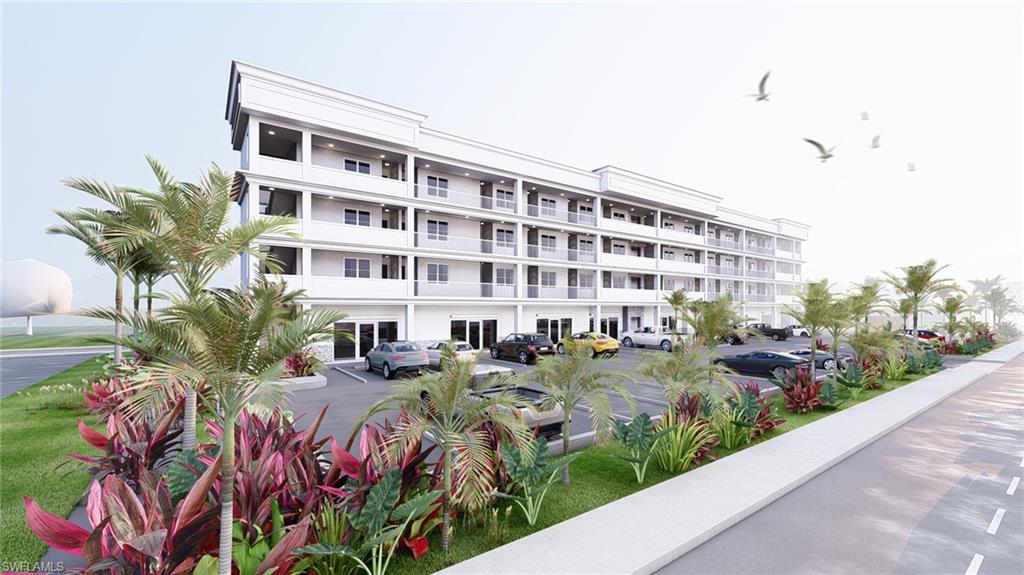 View of apartment building / complex with uncovered parking