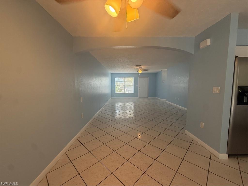 Spacious interior featuring cool-toned walls and square tile flooring