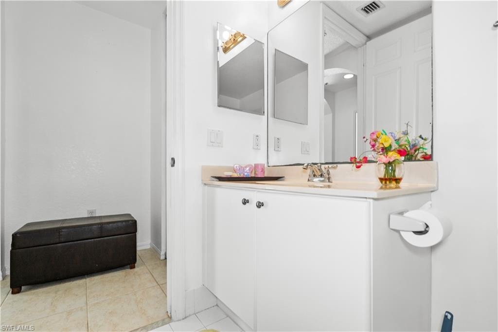 Half bathroom featuring vanity and light tile patterned flooring