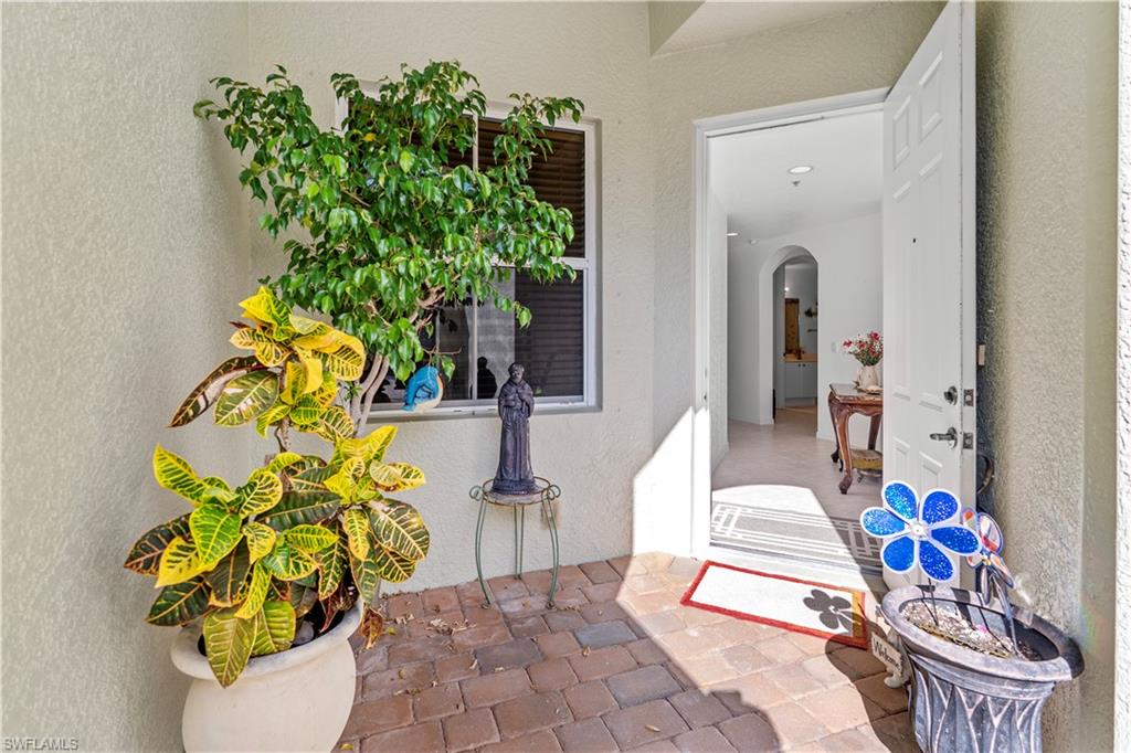 View of exterior entry featuring stucco siding and a patio area