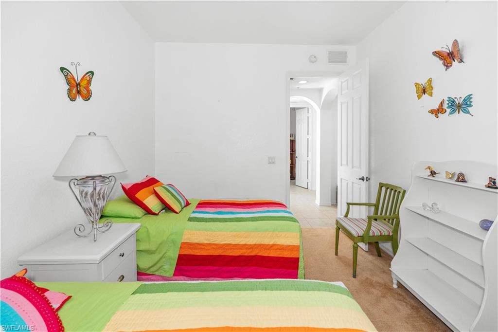 Bedroom featuring arched walkways and carpet flooring