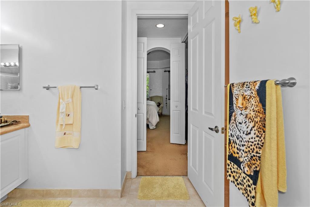 Bathroom featuring light colored carpet, connected bathroom, vanity, and recessed lighting