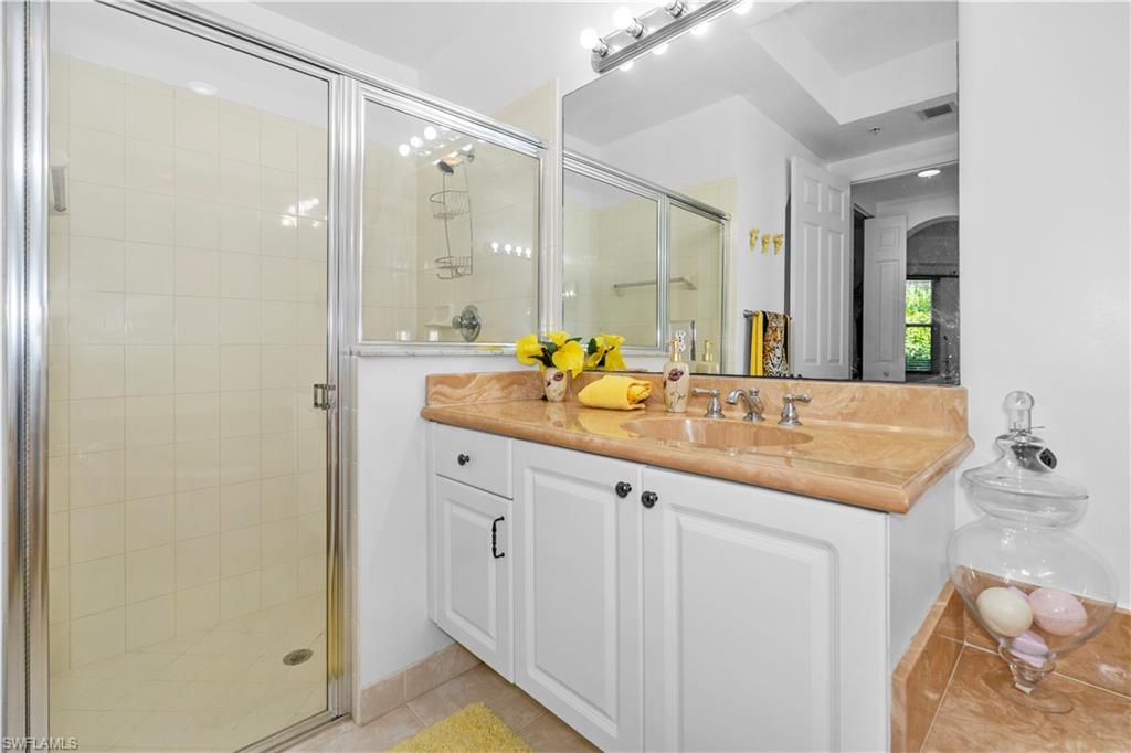 Full bath with vanity, a stall shower, and light tile patterned flooring