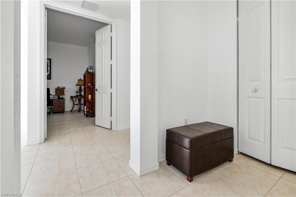 Hallway with baseboards and light tile patterned flooring