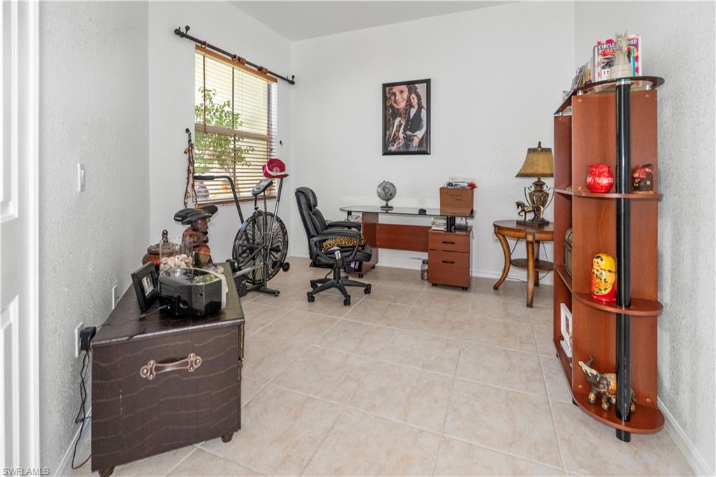 Office space with baseboards and light tile patterned floors