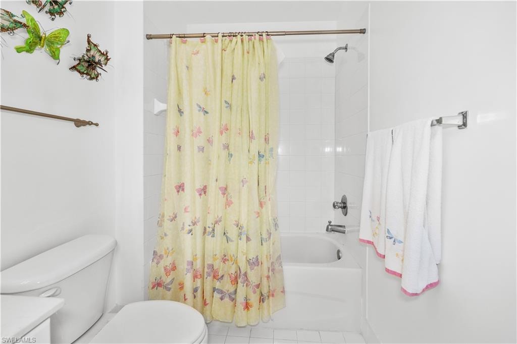 Bathroom with shower / bath combo, vanity, and tile patterned floors