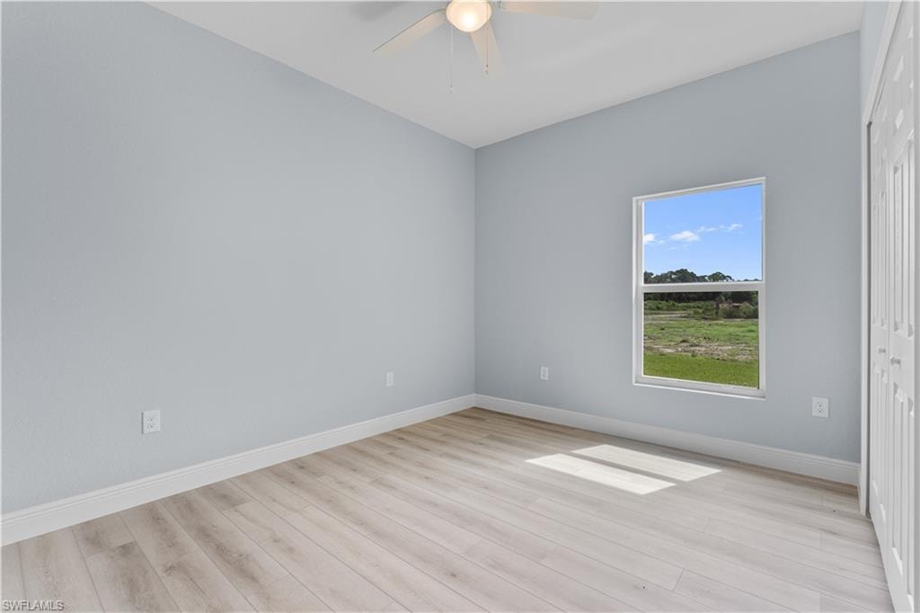 Spare room with light wood-type flooring and ceiling fan
