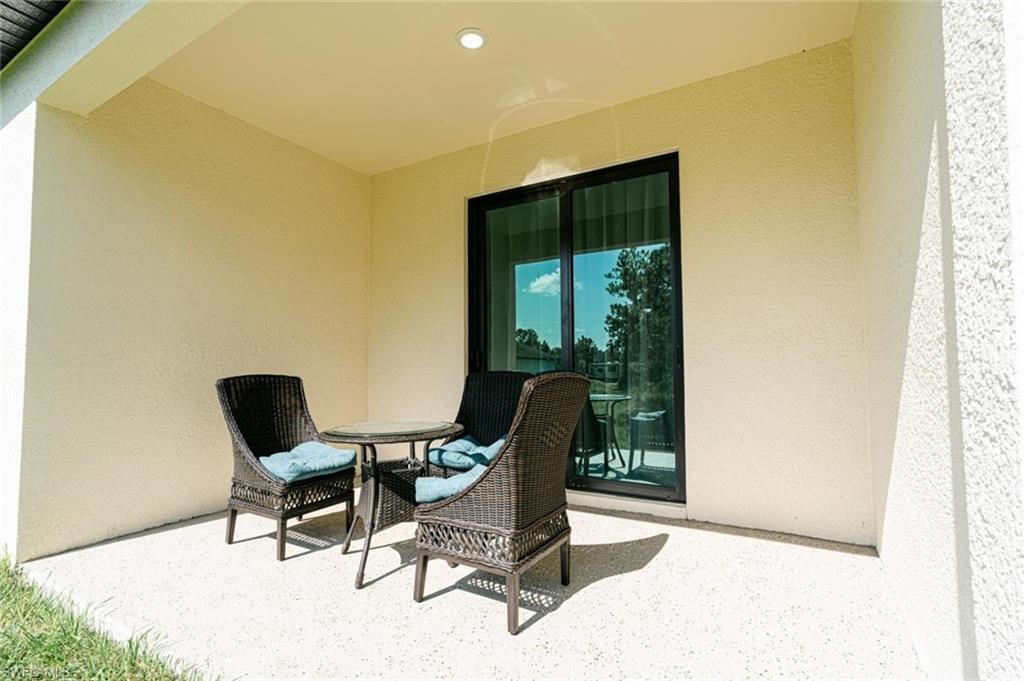 Covered outdoor patio with textured wall finish and recessed lighting