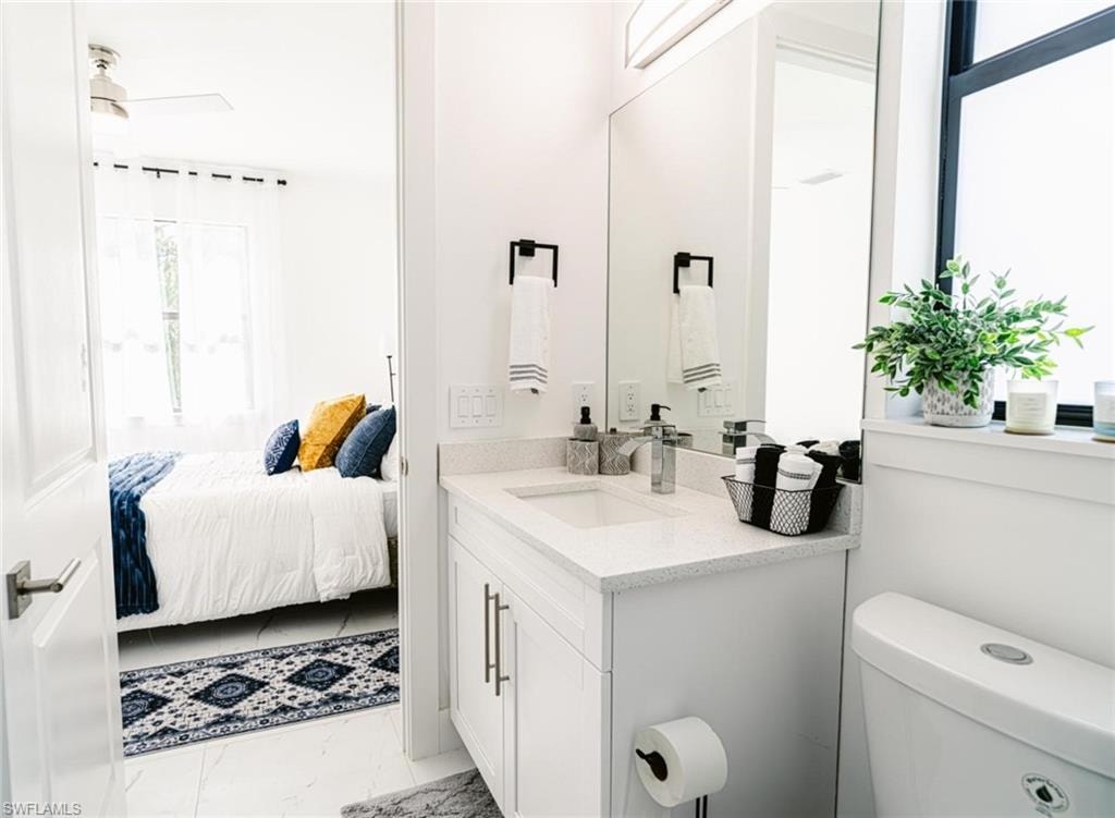 Contemporary bathroom featuring a single vanity with quartz countertop, white cabinetry with silver-tone hardware, and an undermount sink with a chrome faucet