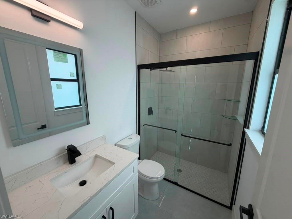 Modern bathroom featuring a white vanity with a quartz-finish countertop and an undermount sink