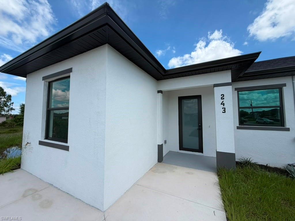 Contemporary exterior featuring white stucco and dark trim
