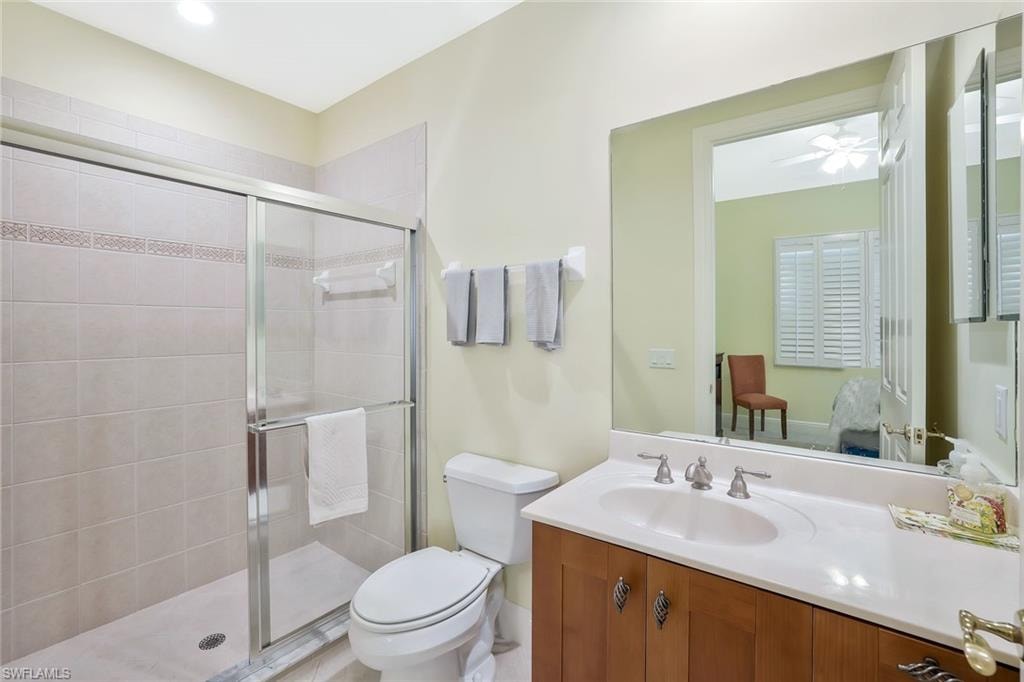 Full bath featuring vanity, a stall shower, and ceiling fan