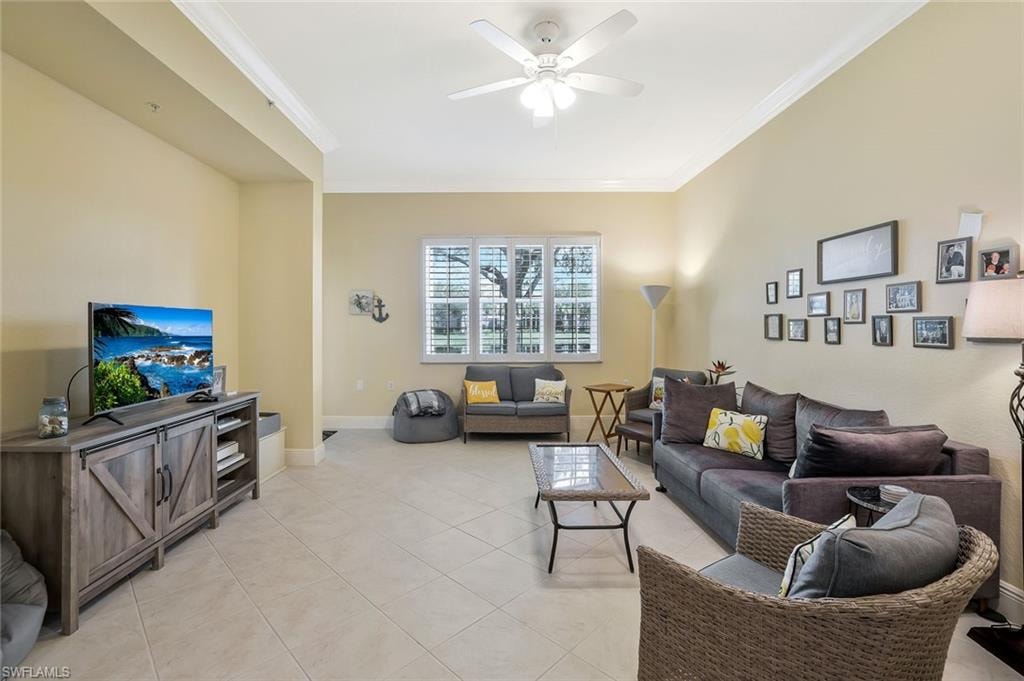 Living area with ornamental molding, ceiling fan, and light tile patterned floors