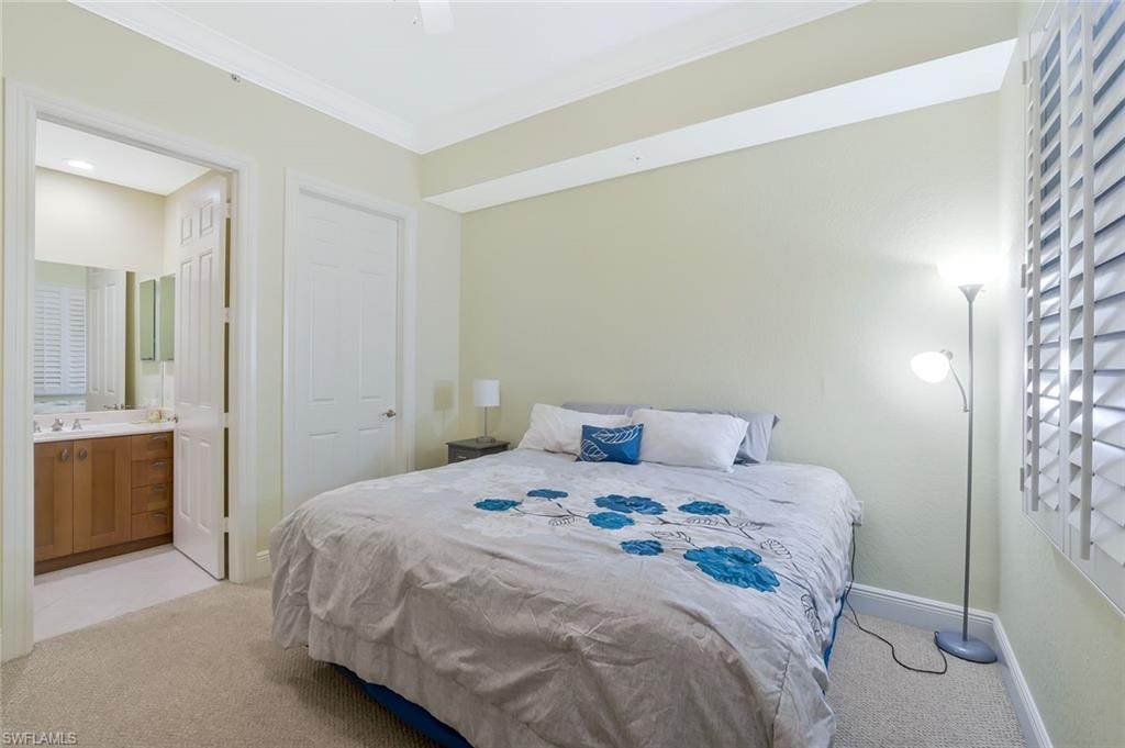 Bedroom featuring light carpet, crown molding, and connected bathroom