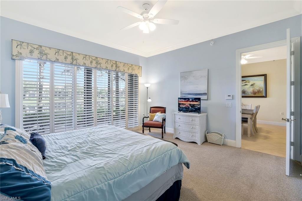 Bedroom featuring carpet floors, crown molding, and ceiling fan