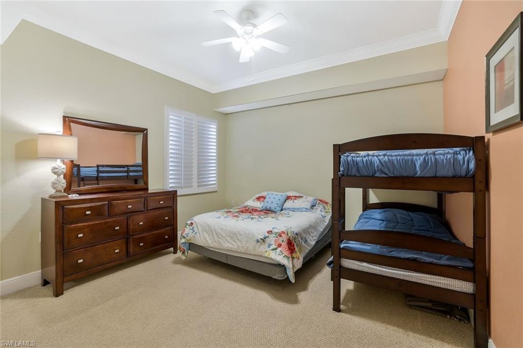 Bedroom with light carpet, ornamental molding, and ceiling fan