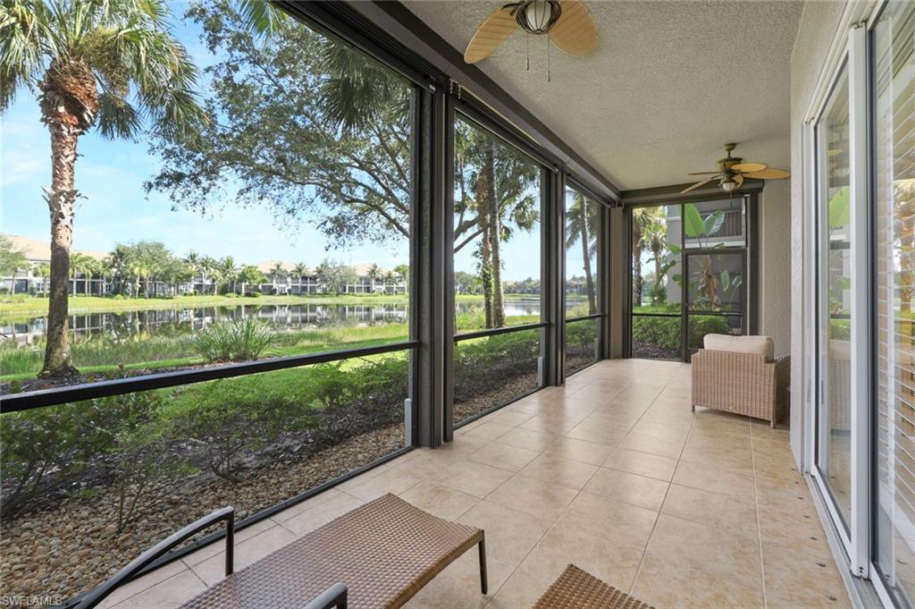 Unfurnished sunroom with a ceiling fan and a water view