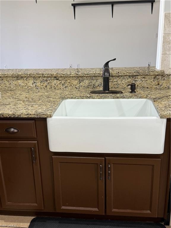 White farmhouse sink with a dark bronze faucet and integrated soap dispenser
