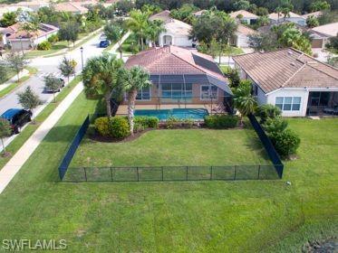 Screened swimming pool, tile roof, and a fenced backyard with established landscaping